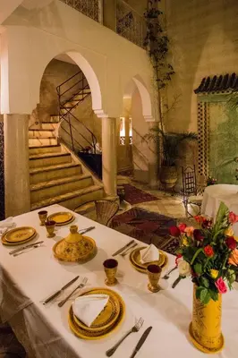 a table with plates and napkins on a table with a table cloth at Riad Light Of Sun in Marrakech