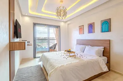a bedroom with a large bed and a chandelier at Studio Haut de Gamme in Marrakech
