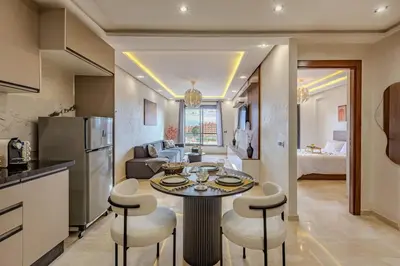 a kitchen and living room with a table and chairs at Studio Haut de Gamme in Marrakech
