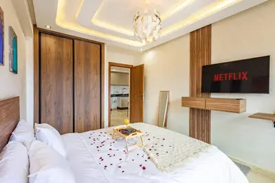 a bedroom with a white bed and a tv at Studio Haut de Gamme in Marrakech