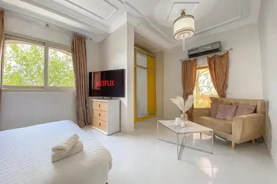 a bedroom with a bed and a couch and a tv at Villa luxueuse marrakech in Marrakech