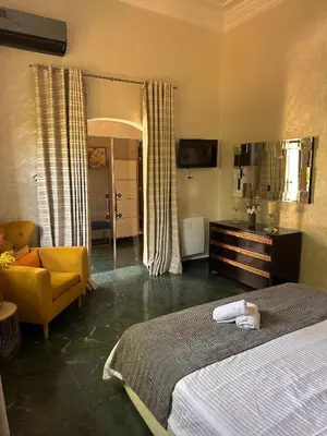 a bedroom with a large bed and a yellow chair at Villa luxueuse marrakech in Marrakech
