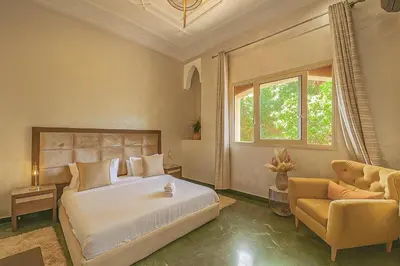 a bedroom with a bed and a couch and a window at Villa luxueuse marrakech in Marrakech