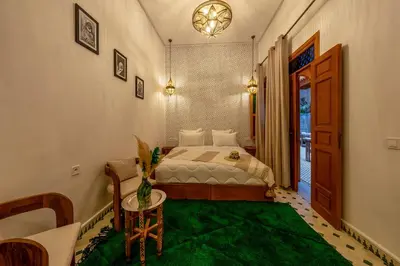 a bedroom with a bed and a green rug at Riad AL-Ghazlan Hamam & Spa in Marrakech