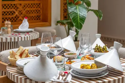 a table with plates of food and wine glasses at Riad AL-Ghazlan Hamam & Spa in Marrakech