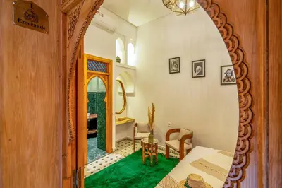 a room with a mirror and a table and a chair at Riad AL-Ghazlan Hamam & Spa in Marrakech