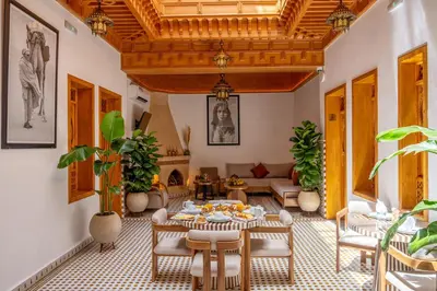 a living room with a table and chairs and a couch at Riad AL-Ghazlan Hamam & Spa in Marrakech