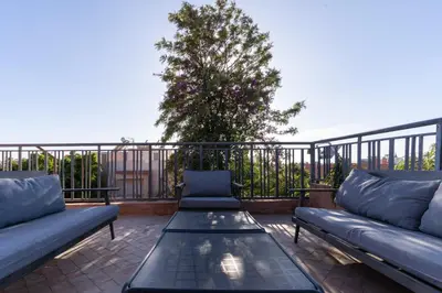 a patio with couches and a table on a balcony at Villa centre Marrakech piscine sans vis-à-vis et Jacuzzi in Marrakech