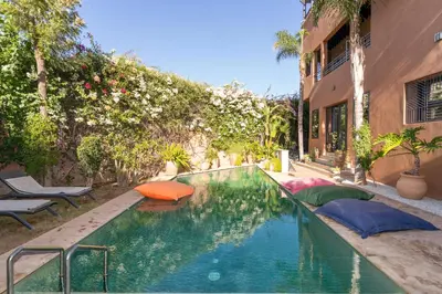 a swimming pool with pillows next to a building at Villa centre Marrakech piscine sans vis-à-vis et Jacuzzi in Marrakech