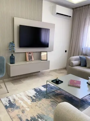 a living room with a flat screen tv on a wall at Nejma House - 1 BR with pool in Marrakech