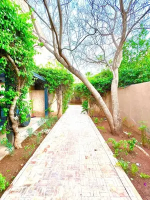 a walkway with trees on the side of a building at Nice Villa Prestigia golf city marrakech in Marrakech