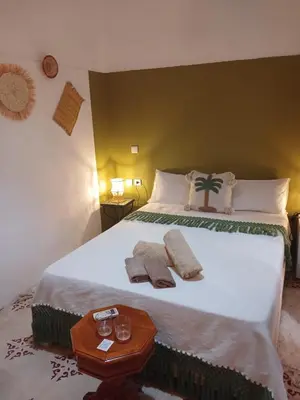 a bedroom with a large bed with two towels on it at Riad Dantella in Marrakech