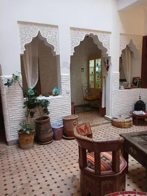 a living room with a table and some potted plants at Riad Dantella in Marrakech
