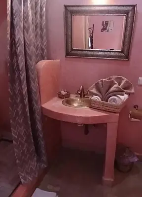 a pink bathroom with a sink and a mirror at Riad Dantella in Marrakech