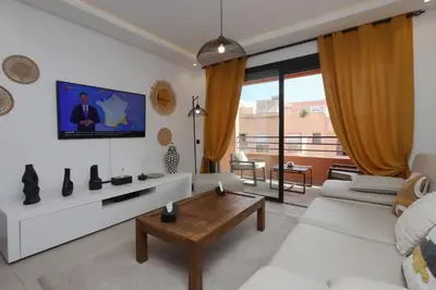 a living room with a white couch and a tv at Modern top floor apartment with balcony! in Marrakech