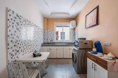 a small kitchen with a small table and a sink at RED YACOUT Parking Sécurisé in Marrakech