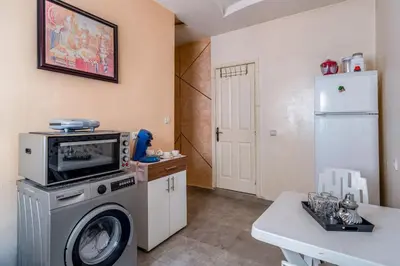 a kitchen with a washing machine and a refrigerator at RED YACOUT Parking Sécurisé in Marrakech