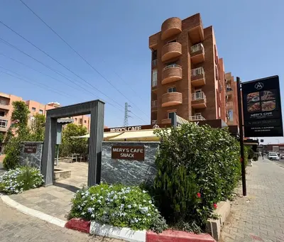 a building with a sign on the side of a street at RED YACOUT Parking Sécurisé in Marrakech