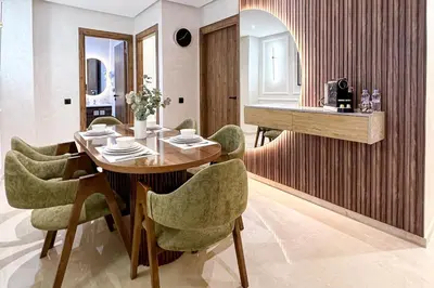 a dining room with a wooden table and green chairs at Stylish Escape Modern Comforts in Marrakech
