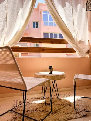 a table and a chair in front of a window at Stylish Escape Modern Comforts in Marrakech
