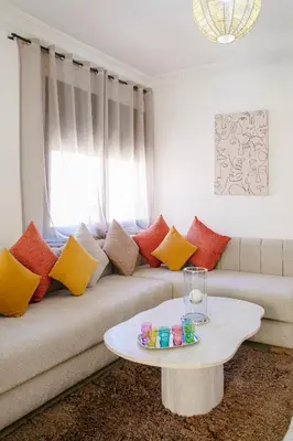 a living room with a couch with colorful pillows at Refuge Peachy Guéliz et Confort in Marrakech