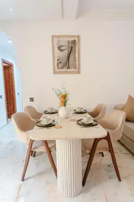a living room with a table and chairs at Refuge Peachy Guéliz et Confort in Marrakech
