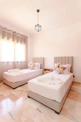 two beds in a room with white walls at Refuge Peachy Guéliz et Confort in Marrakech