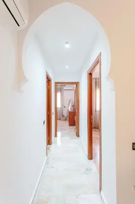 a hallway of a house with white walls and a mirror at Refuge Peachy Guéliz et Confort in Marrakech