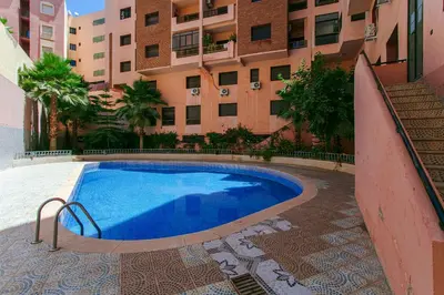 a swimming pool in front of a building at Refuge Peachy Guéliz et Confort in Marrakech