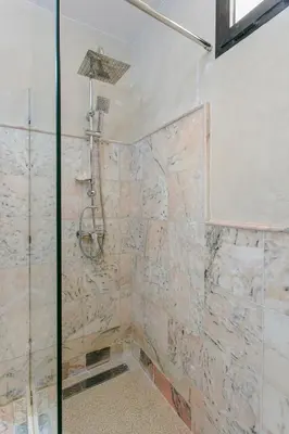 a bathroom with a shower with a stone wall at Refuge Peachy Guéliz et Confort in Marrakech