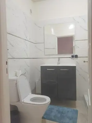 a bathroom with a toilet and a sink and a mirror at Chic 2BR Apartment with Beautiful Moroccan Salon in Marrakech