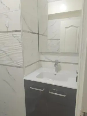 a white bathroom with a sink and a mirror at Chic 2BR Apartment with Beautiful Moroccan Salon in Marrakech