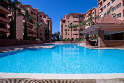 a large swimming pool in front of some buildings at Chic 2BR Apartment with Beautiful Moroccan Salon in Marrakech