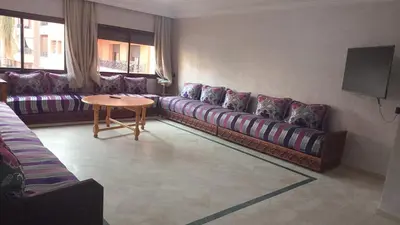 a living room with couches and a table at Chic 2BR Apartment with Beautiful Moroccan Salon in Marrakech
