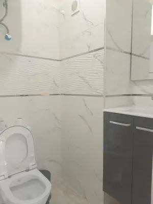 a white bathroom with a toilet and a sink at Chic 2BR Apartment with Beautiful Moroccan Salon in Marrakech