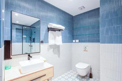 a blue tiled bathroom with a sink and a toilet at Triplex luxe marrakech in Marrakech