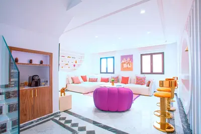 a living room with a pink ottoman and a couch at Triplex luxe marrakech in Marrakech