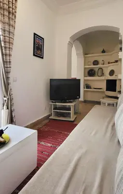 a living room with a flat screen tv and a couch at Riad Bouchra, riad privatif proche de la place Jemaa-El-Fna in Marrakech