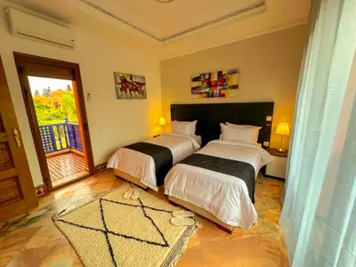 a bedroom with two beds and a large window at Riador in Marrakech