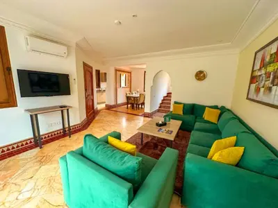 a living room with a green couch and a table at Riador in Marrakech