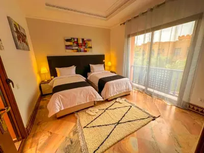 a bedroom with two beds and a large window at Riador in Marrakech
