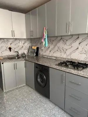a kitchen with white cabinets and a washing machine at dar shahd in Marrakech