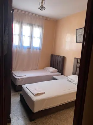 two beds in a room with a window at dar shahd in Marrakech