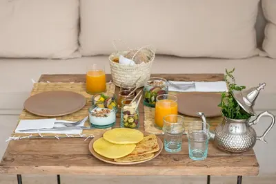 a table with plates of food and glasses of orange juice at Riad Dar Mimi in Marrakech