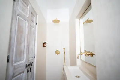 a white bathroom with a sink and a mirror at Riad Dar Mimi in Marrakech