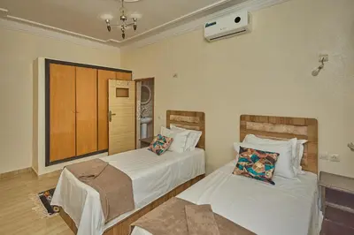 a bedroom with two beds with white sheets at Dar Hma in Marrakech