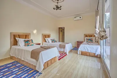 a bedroom with two beds and a window at Dar Hma in Marrakech