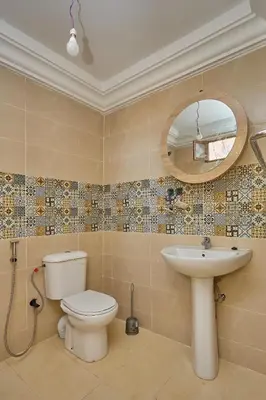 a bathroom with a toilet and a sink and a mirror at Dar Hma in Marrakech