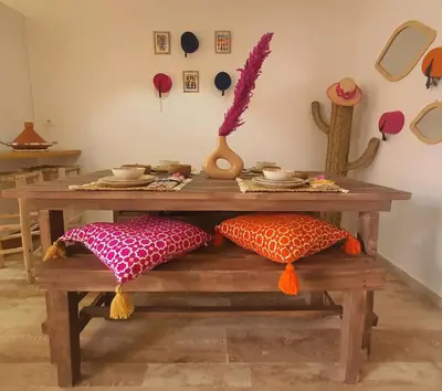 a wooden table with pillows on a wooden bench at Peaceful one terrace suite, gueliz in Marrakech