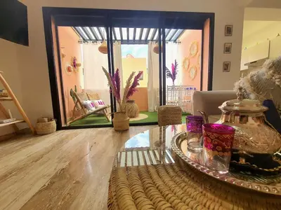 a living room with a glass table and a room with a window at Peaceful one terrace suite, gueliz in Marrakech